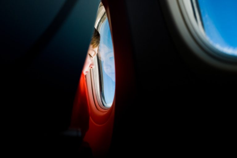 child looking out airplane window