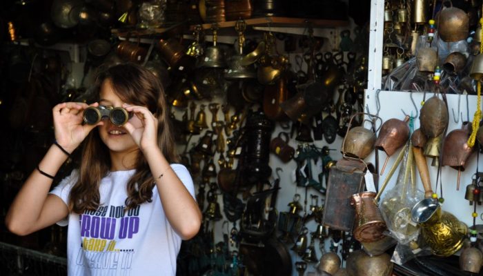 Girl looking through binoculars things to do Chania Greece